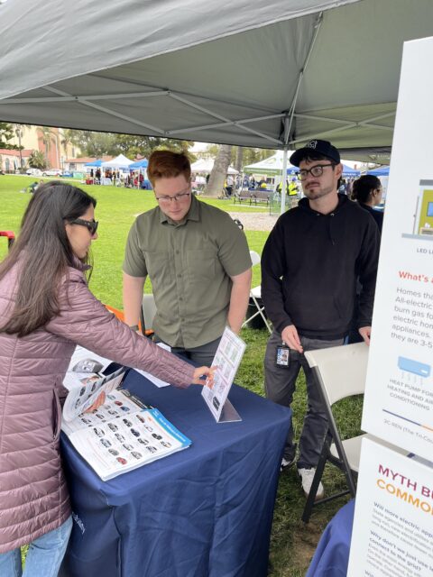 VCREA staff assisting an attendee on EV rebates